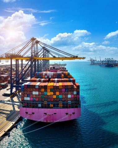Aerial view of cargo ship and cargo container in harbor.